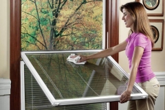 A Homeowner Cleaning A Window With A Soft Cloth