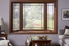 View of A Bay Window Located In A Living Space Overlooking A Grassy Piece Of Land