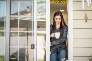 Homeowner walking out of sliding glass door holding coffee