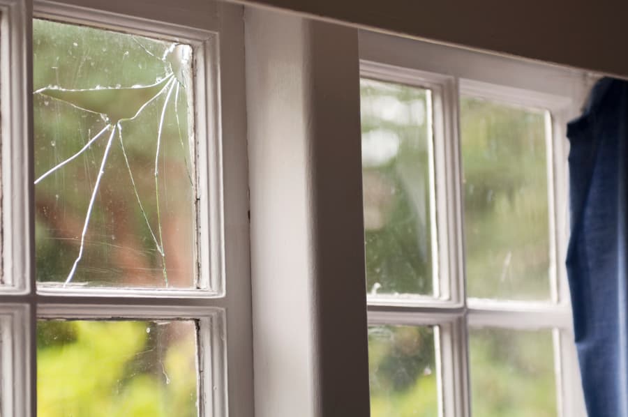 Horizontal image of a damaged window pane in an old house