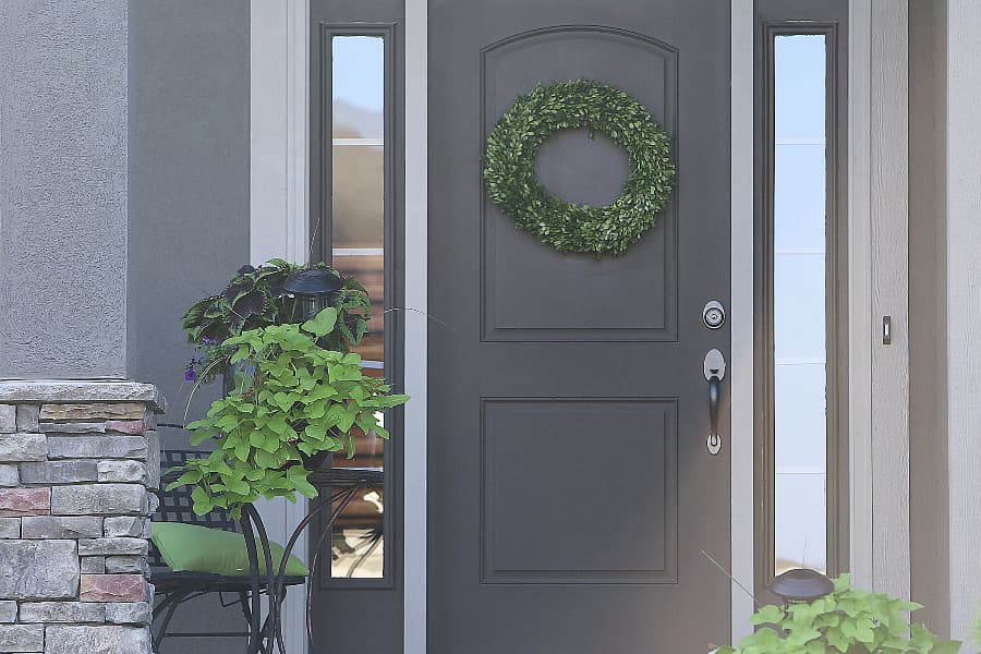 gray front door with wreath and planters